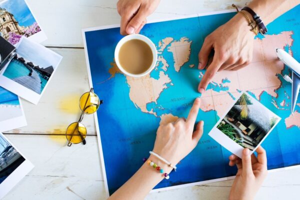 Traveler organizing a vacation itinerary with a map and travel essentials